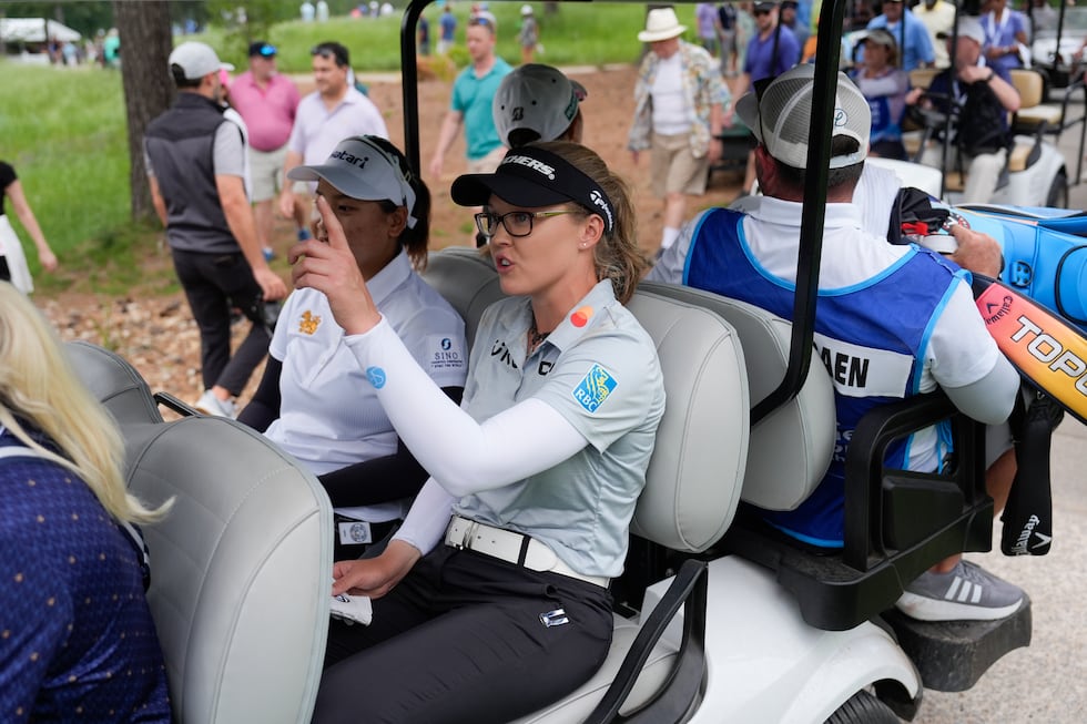 Brooke Henderson, of Canada, leaves the course during as play is stopped due to weather during...