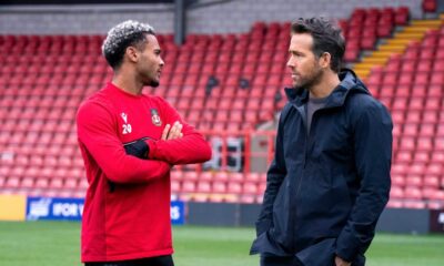 This image released by FX shows Dior Angus, left, and Ryan Reynolds in a scene from the docuseries "Welcome to Wrexham," which follows owners Reynolds and Rob McElhenney as they take over the lower-league Welsh soccer team Wrexham AFC. (Patrick McElhenney/FX via AP)