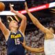 The Denver Nuggets' Nikola Jokic (15) goes to the basket against the Minnesota Timberwolves' Karl-Anthony Towns.