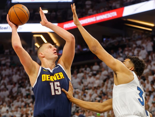 The Denver Nuggets' Nikola Jokic (15) goes to the basket against the Minnesota Timberwolves' Karl-Anthony Towns.