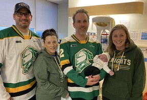 Paul and Cathy Willmore wear London Knights gear with Ryan, Dawson and Sarah Arbeau, shortly after Dawson was born. Cathy Willmore, mother of Knights backup goalie Owen Willmore, was the surrogate who carried Ryan and Sarah’s embyro to term. Ryan Arbeau is a team doctor. (Supplied photo)