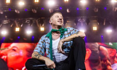 Macklemore onstage with a delightful duck-print short-sleeve shirt.