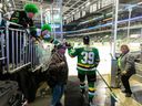 Jeff McCarty and his son Liam, 12, put on green wigs and get high fives from London Knights forward Max McCue before Game 5 of the Ontario Hockey League Western Conference final against Saginaw on May 3, 2024. (Mike Hensen/ The London Free Press) 