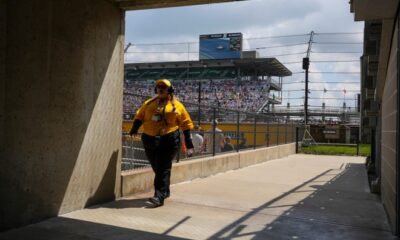 A yellow shirt IMS employee walks away from the stands, Saturday, May 18, 2024, during qualifying for the 108th running of the Indianapolis 500 at Indianapolis Motor Speedway.