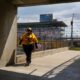 A yellow shirt IMS employee walks away from the stands, Saturday, May 18, 2024, during qualifying for the 108th running of the Indianapolis 500 at Indianapolis Motor Speedway.