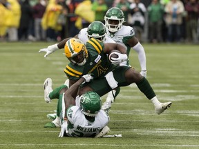 The Edmonton Elks' Kevin Brown (4) is tackled by the Saskatchewan Roughriders' Deontai Williams (24) during CFL action at Commonwealth Stadium, In Edmonton Saturday June 8, 2024.
