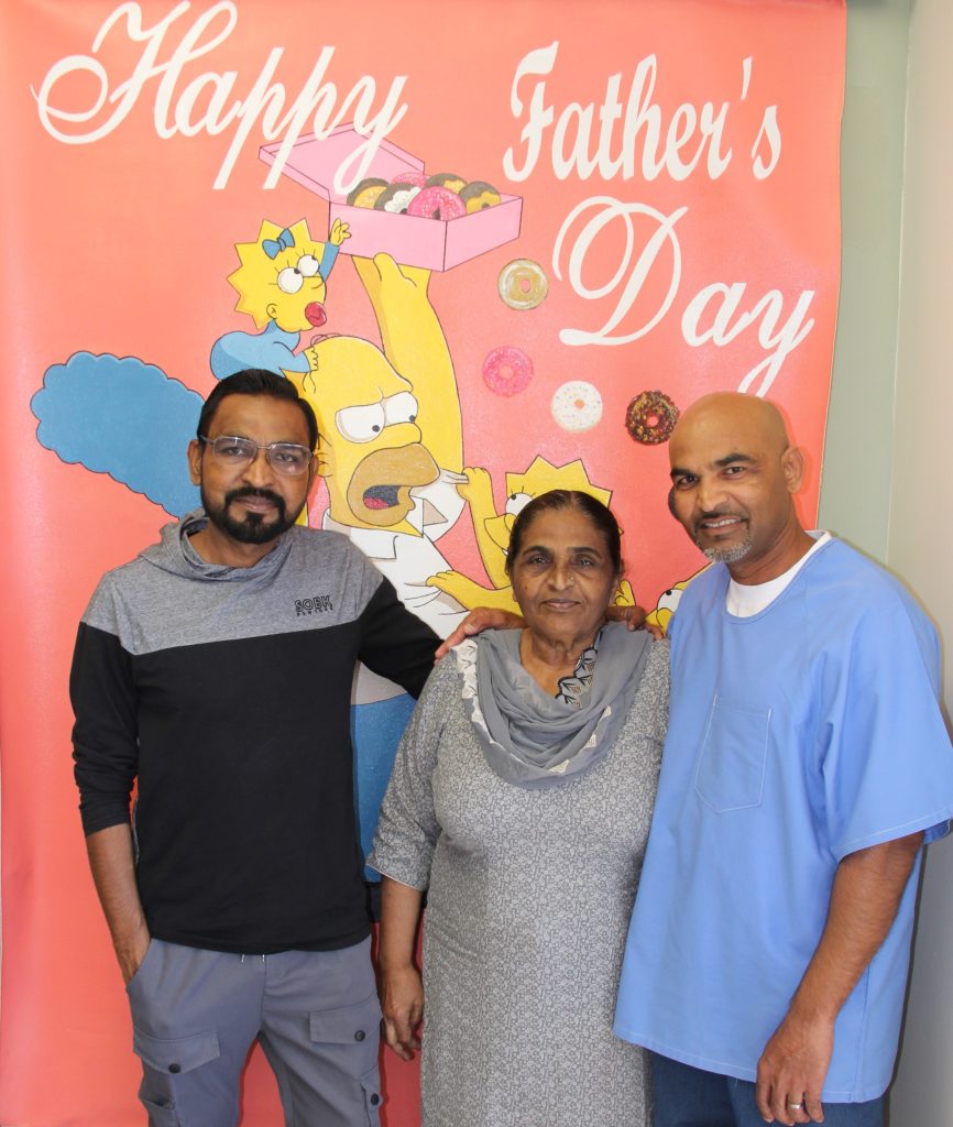 Incarcerated man poses for a photo with a woman and another man.