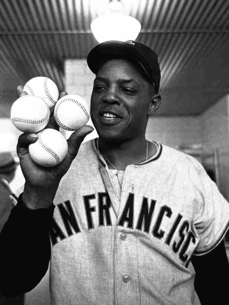 Giant star outfielder, Willie Mays, proudly displays the four baseballs representing the four homers which he hit against the Milwaukee Braves on April 30, 1961