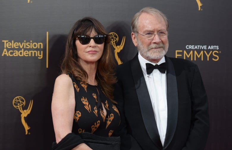 Two people in formal wear pose for photographs.