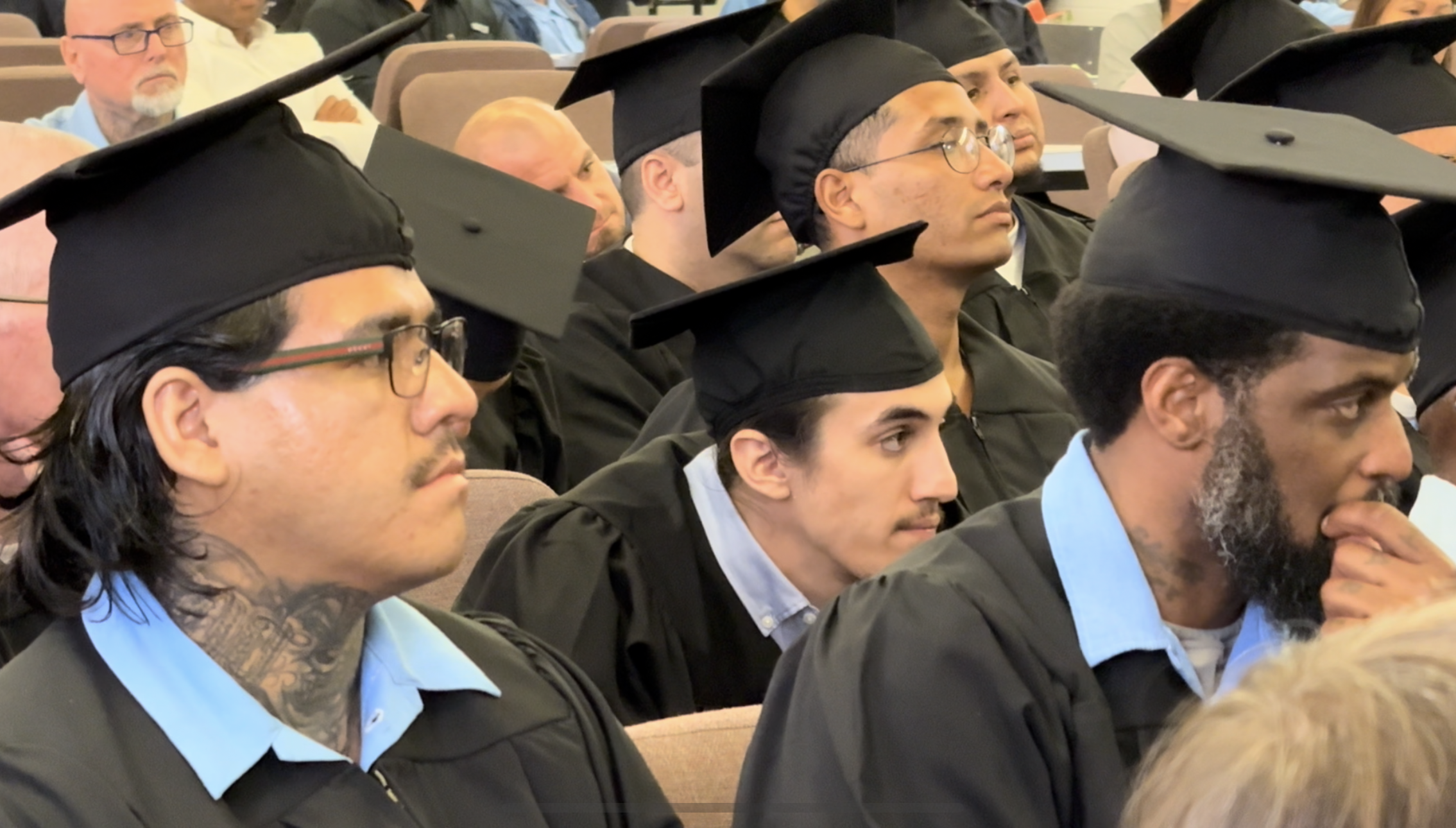 Incarcerated students wearing caps and gowns prepare to graduate the second American Sign Language class at San Quentin Rehabilitation Center.