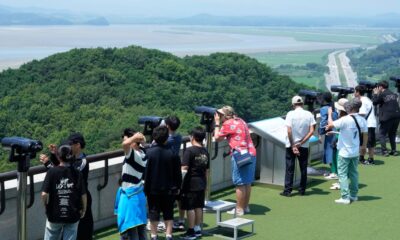 Visitors watch North Korean side from the Unification Observation Post in Paju, South Korea, near the border with North Korea, Tuesday, June 18, 2024. South Korean soldiers fired warning shots to repel North Korean soldiers who temporarily crossed the rivals' land border Tuesday for the second time this month, South Korea's military said. (AP Photo/Ahn Young-joon)