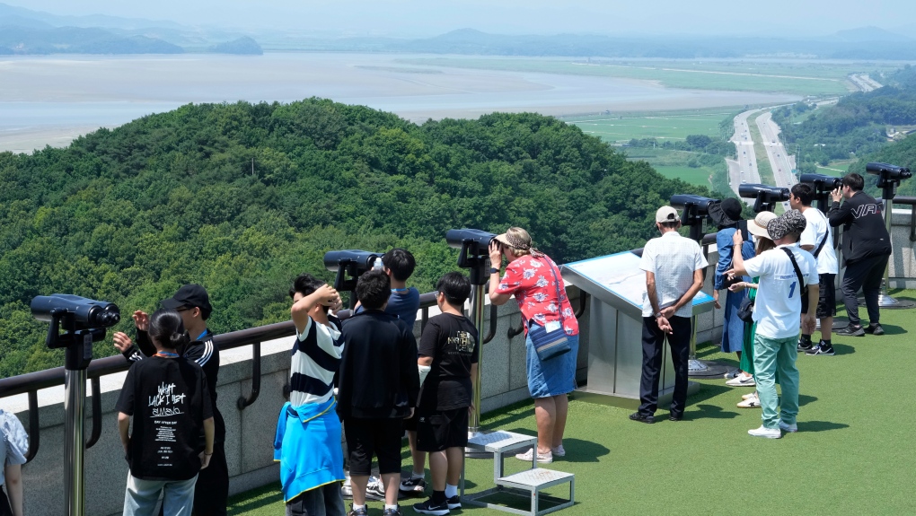 Visitors watch North Korean side from the Unification Observation Post in Paju, South Korea, near the border with North Korea, Tuesday, June 18, 2024. South Korean soldiers fired warning shots to repel North Korean soldiers who temporarily crossed the rivals' land border Tuesday for the second time this month, South Korea's military said. (AP Photo/Ahn Young-joon)