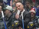 Vancouver Canucks head coach Rick Tocchet, back, stands on the bench behind Ilya Mikheyev (65) and Nils Aman (88) during the third period of an NHL hockey game against the San Jose Sharks in Vancouver, on Saturday, December 23, 2023.