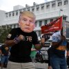 A man wears a mask of former President Donald Trump in front of a Fort Pierce, Fla., courthouse.