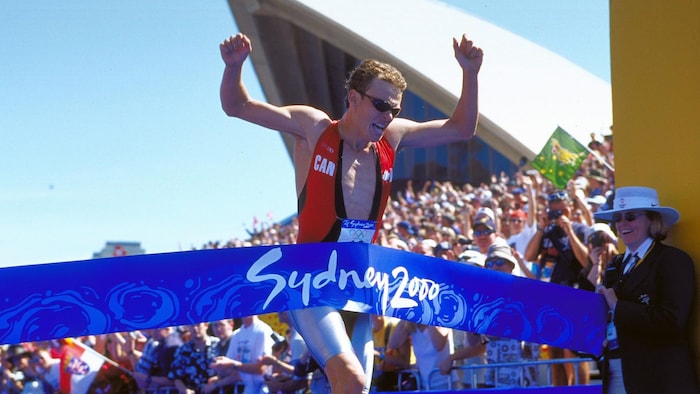 Il brise la banderole sur laquelle est écrit Sydney 2000.