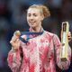 Eleanor Harvey poses with her medal and a box containing a poster on the podium