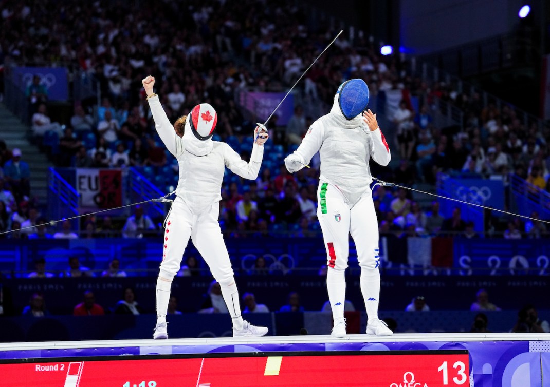 Eleanor Harvey pumps her fist in the air in victory in a fencing match 