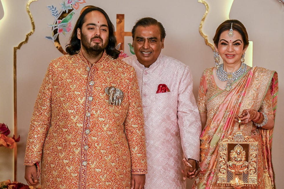 Billionaire tycoon and Chairman of Reliance Industries Mukesh Ambani (C), wife Nita Ambani (R) and son Anant Ambani pose for photos as they arrive to attend the wedding ceremony of Anant and his fiancee Radhika Merchant in Mumbai on July 12, 2024.