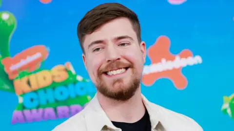 Getty Images MrBeast aka Jimmy Donaldson at the Nickelodeon Kids Choice Awards. Jimmy has short brown hair and a short brown beard. 