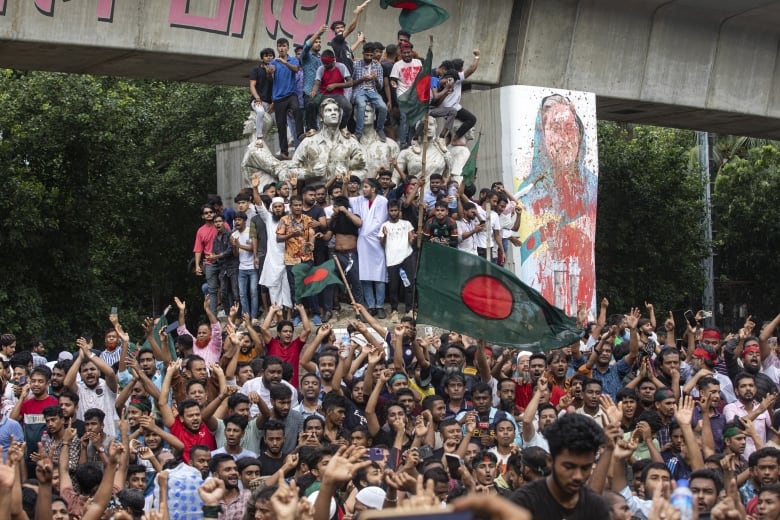 Protesters climb a public monument.