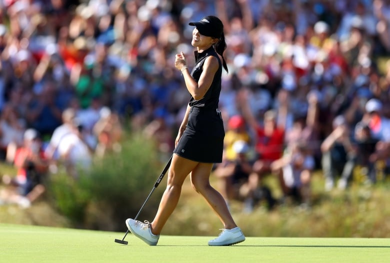 A female golfer is seen celebrating.