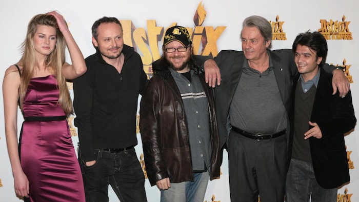 Les cinq acteurs posent devant un mur sur lequel est écrit Astérix et les Jeux olympiques. 