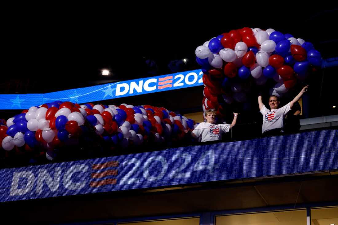 Workers set up balloons before they are lifted above the floor of the United Center for the DNC on Friday in Chicago. The official programming begins Monday.