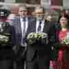 British Prime Minister Keir Starmer (center) carries a floral tribute on Tuesday near the scene of a deadly knife attack at a dance school a day earlier in Southport, England.