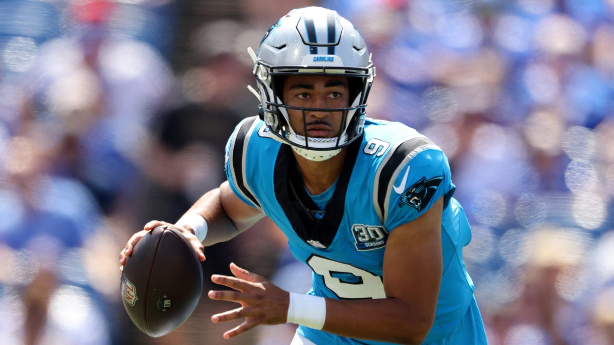 Carolina Panthers quarterback Bryce Young  running with the ball held in his right hand.