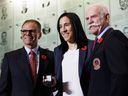 Caroline Ouellette, centre, receives her Hockey Hall of Fame ring from Mike Gartner, left, and Lanny McDonald.