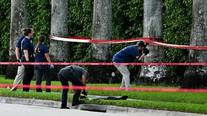 Des agents du FBI inspectent un secteur boisé près d'une rue.