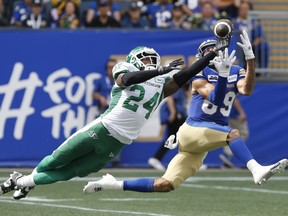 Saskatchewan Roughriders' Deontai Williams (24) knocks the pass away from Winnipeg Blue Bombers' Kenny Lawler (89) during the first half of CFL action in Winnipeg on Saturday, Sept. 7, 2024.