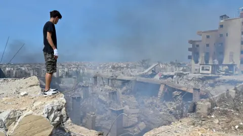 EPA A man looks at the damaged caused by an Israeli airstrike in Choueifat, southeast of Beirut, Lebanon, on 28 September 2024.