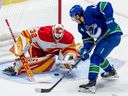 Flames goaltender Dustin Wolf stops Canucks winger Kiefer Sherwood during first period NHL pre-season play Wednesday at Abbotsford.