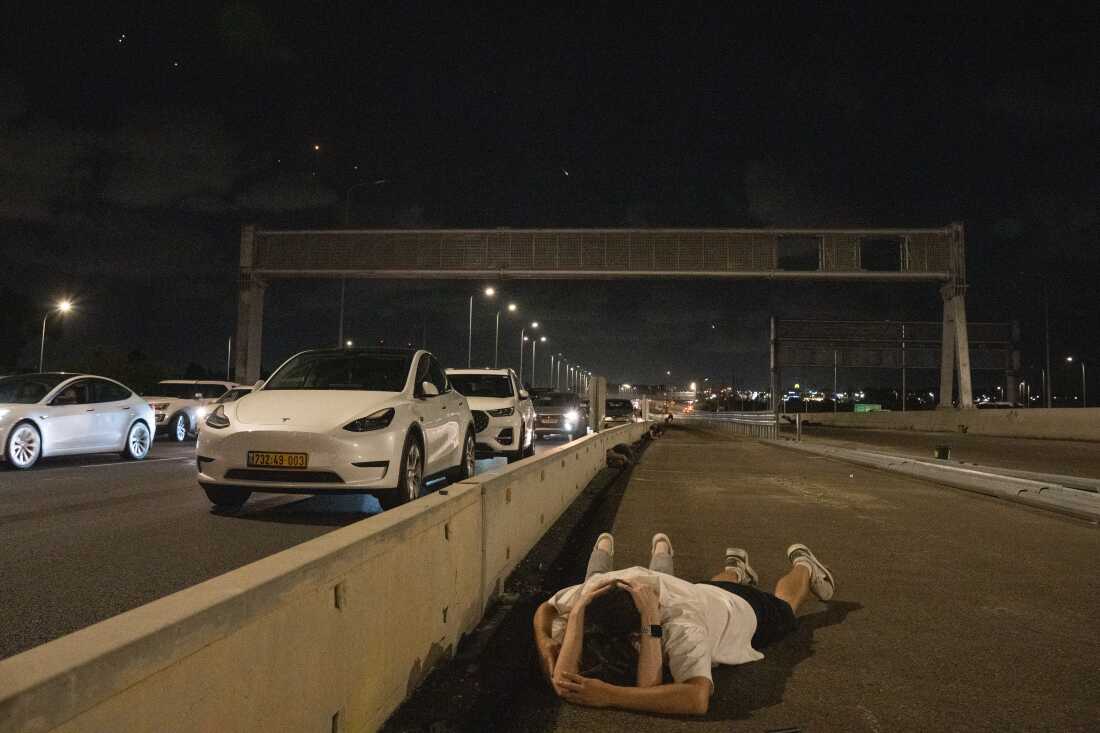 Israelis shelter on the highway during a massive missile barrage from Iran on Tuesday Oct.1, 2024.