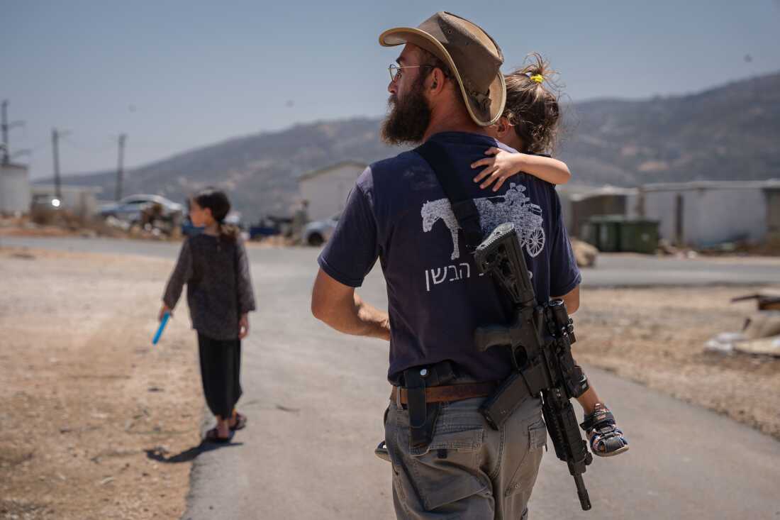 Malkiel Bar-Chai holds his daughter in the outpost settlement of Evyatar, which had recently received authorization from Israel, in the Israeli-occupied West Bank, on July 18.