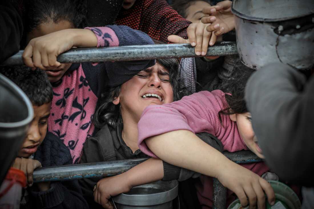 A Palestinian child cries among children waiting for food prepared by volunteers for Palestinian families who fled to southern Gaza due to Israeli attacks, in Rafah, Gaza Strip, on Feb. 10.