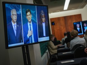 B.C. Conservative Leader John Rustad, from left to right, B.C. NDP Leader David Eby and B.C. Green Party Leader Sonia Furstenau are seen on television screens as reporters watch the televised leaders' debate in Vancouver on Tuesday, October 8, 2024.