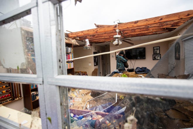 Connor Ferran, a Fort Myers resident carries his dog out home that was damaged in a possible tornado associated with Hurricane Milton on Wednesday, Oct. 9, 2024.