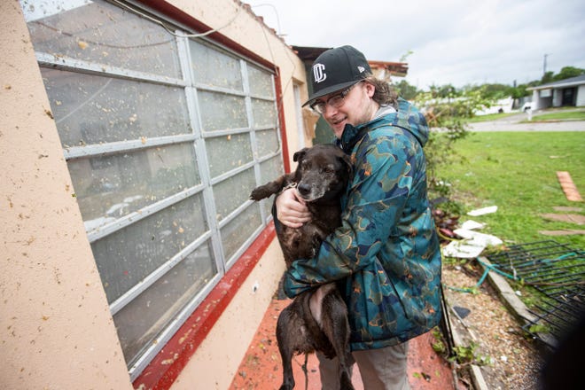 Connor Ferran, a Fort Myers resident carries his dog out of his home that was damaged in a possible tornado associated with Hurricane Milton on Wednesday, Oct. 9, 2024.