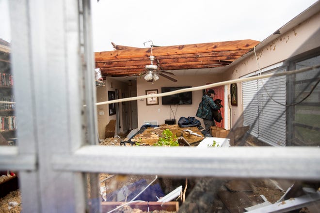 Connor Ferran, a Fort Myers resident carries his dog out of his home that was damaged in a possible tornado associated with Hurricane Milton on Wednesday, Oct. 9, 2024.