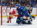 Calgary Flames' Connor Zary (47) celebrates his winning goal against Vancouver Canucks goalie Arturs Silovs, back, while being checked by Filip Hronek (17) during overtime at Rogers Arena on Wednesday night