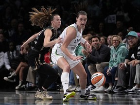 Minnesota Lynx's Bridget Carleton, right, dribbles the ball against New York Liberty's Sabrina Ionescu during the first half in Game 1 of the WNBA final Thursday, Oct. 10, 2024, in New York. (AP Photo/Pamela Smith)