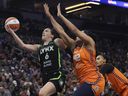 Minnesota Lynx forward Bridget Carleton (6) jumps up to the basket against Connecticut Sun forward Brionna Jones (42) during the first half of Game 1 of a WNBA semifinal on Sunday, Sept. 29, 2024, in Minneapolis. (AP Photo/Stacy Bengs)