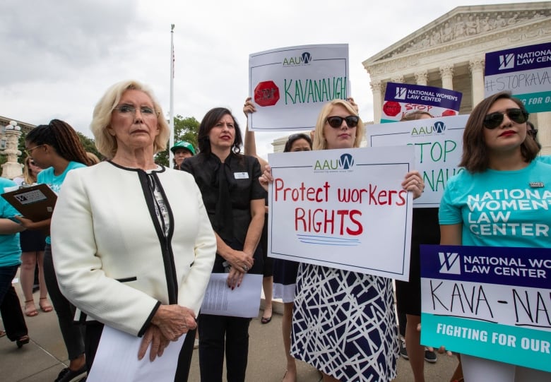 An image of Lilly Ledbetter, an activist for workplace equality, joining demonstrators opposed to President Donald Trump's Supreme Court nominee, Judge Brett Kavanaugh, in front of the Supreme Court.