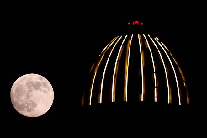 The hunter's supermoon rises behind the dome of a mosque in Doha, the capital of Qatar, on October 16, 2024.