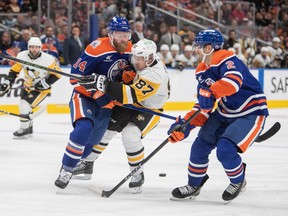 Pittsburgh Penguins' Sidney Crosby (87) is checked by Edmonton Oilers' Mattias Ekholm (14)