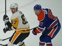 Pittsburgh Penguins captain Sidney Crosby (87) is checked by Edmonton Oilers captain Connor McDavid (97) during first period National Hockey League game action in Edmonton on Monday October 24, 2022.