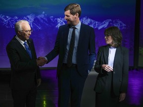 B.C. Conservative Leader John Rustad, left, and B.C. NDP Leader David Eby, centre, shake hands as B.C. Green Party Leader Sonia Furstenau, right, watches while posing for photographs before the televised leaders' debate, in Vancouver, on Tuesday, October 8, 2024.