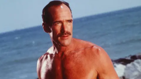 Getty Images Michael Newman in Baywatch, 1997, pictured looking across the beach with the sea in the background